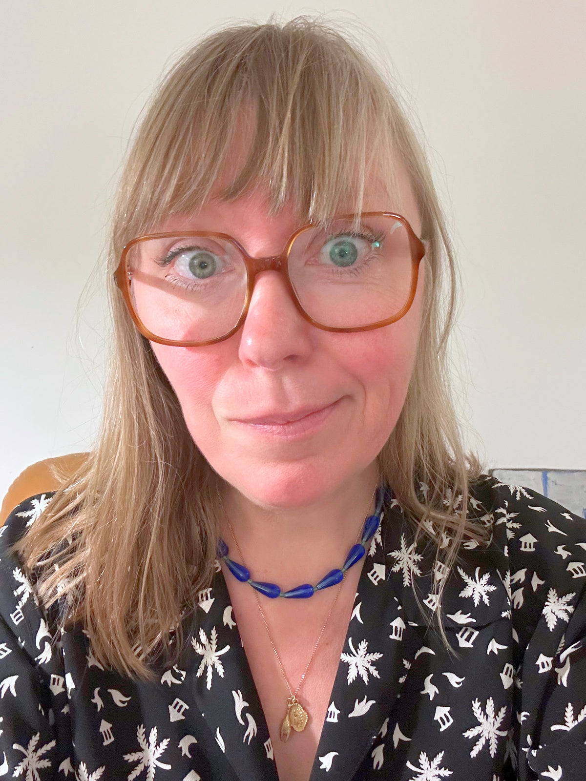 Collier ras du cou en perles de verre goutte bleu porté au cou