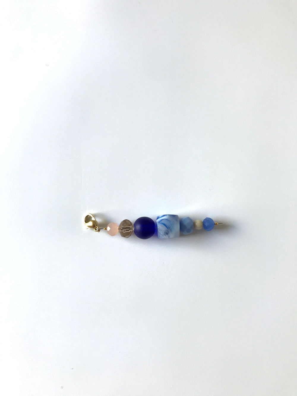 Pendentif extension de chaîne n°3, perles bleu nuit et bleu clair, sur fond blanc