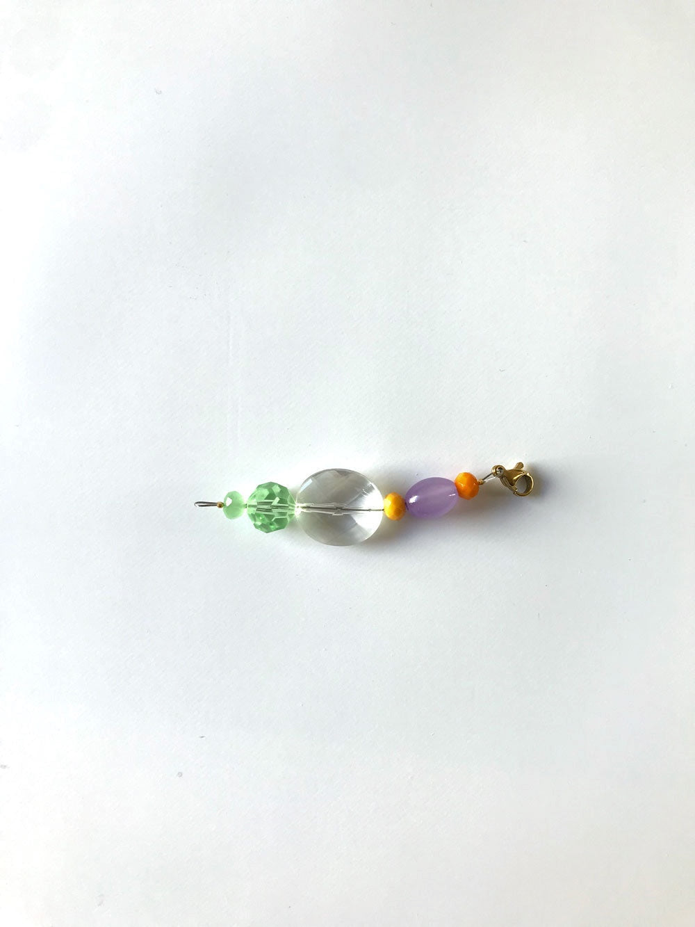 Pendentif extension de chaîne n°4, perles verte, transparente et orange, sur fond blanc