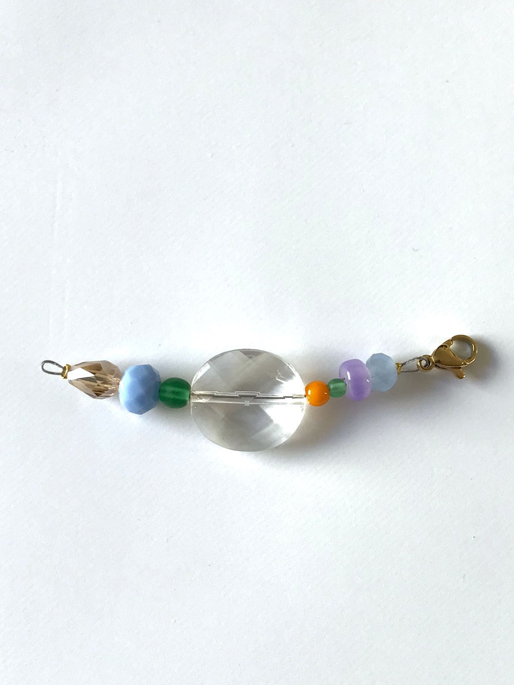 Pendentif extension de chaîne n°6, grosse perle transparente et perles bleue, verte et mauve, sur fond blanc