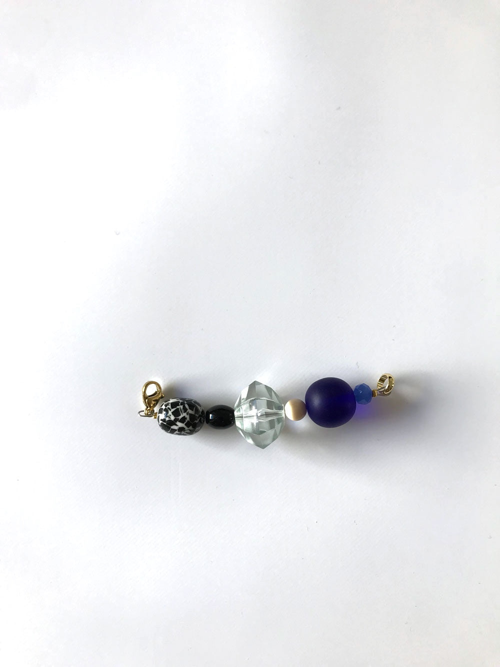Pendentif esprit Memphis bleu, perles noire, transparente facettée et bleu nuit, gros plan