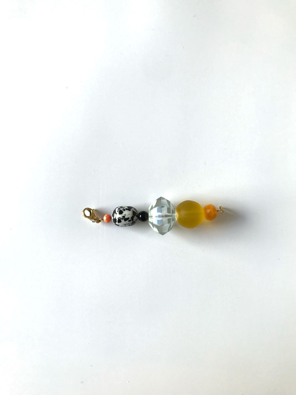 Pendentif esprit Memphis jaune, perles mouchetée, transparente facettée et jaune, gros plan