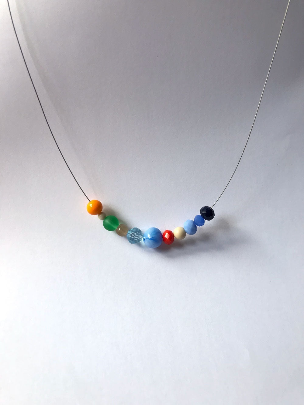 Petit collier n°5 sur fil fin, petites perles bleues, orange et rouges au centre