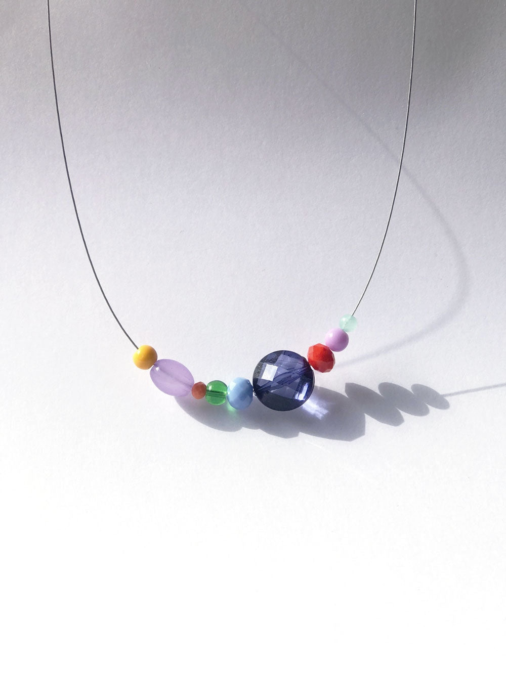 Petit collier n°2 sur fil fin, perle bleu nuit et perles mauves au centre