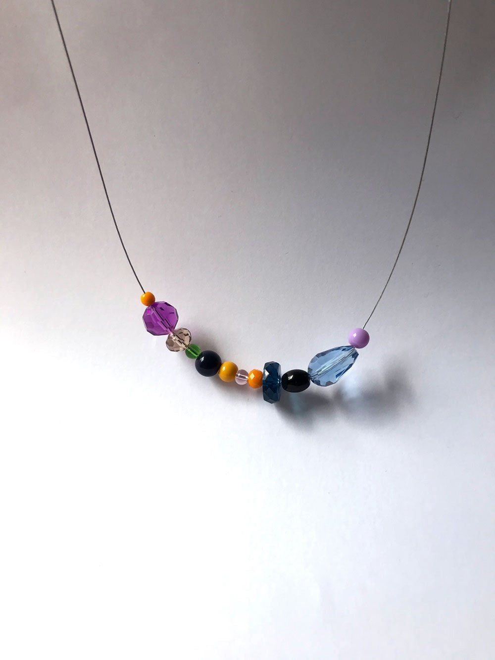 Petit collier n°4 sur fil fin, perles violette, noire et bleue facettée