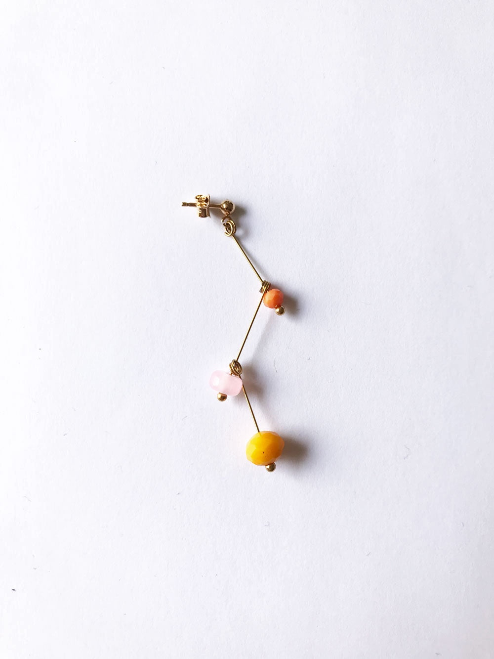 Petite boucle d'oreille mobile n°1, perles orange, rose pâle et jaune, sur fond blanc