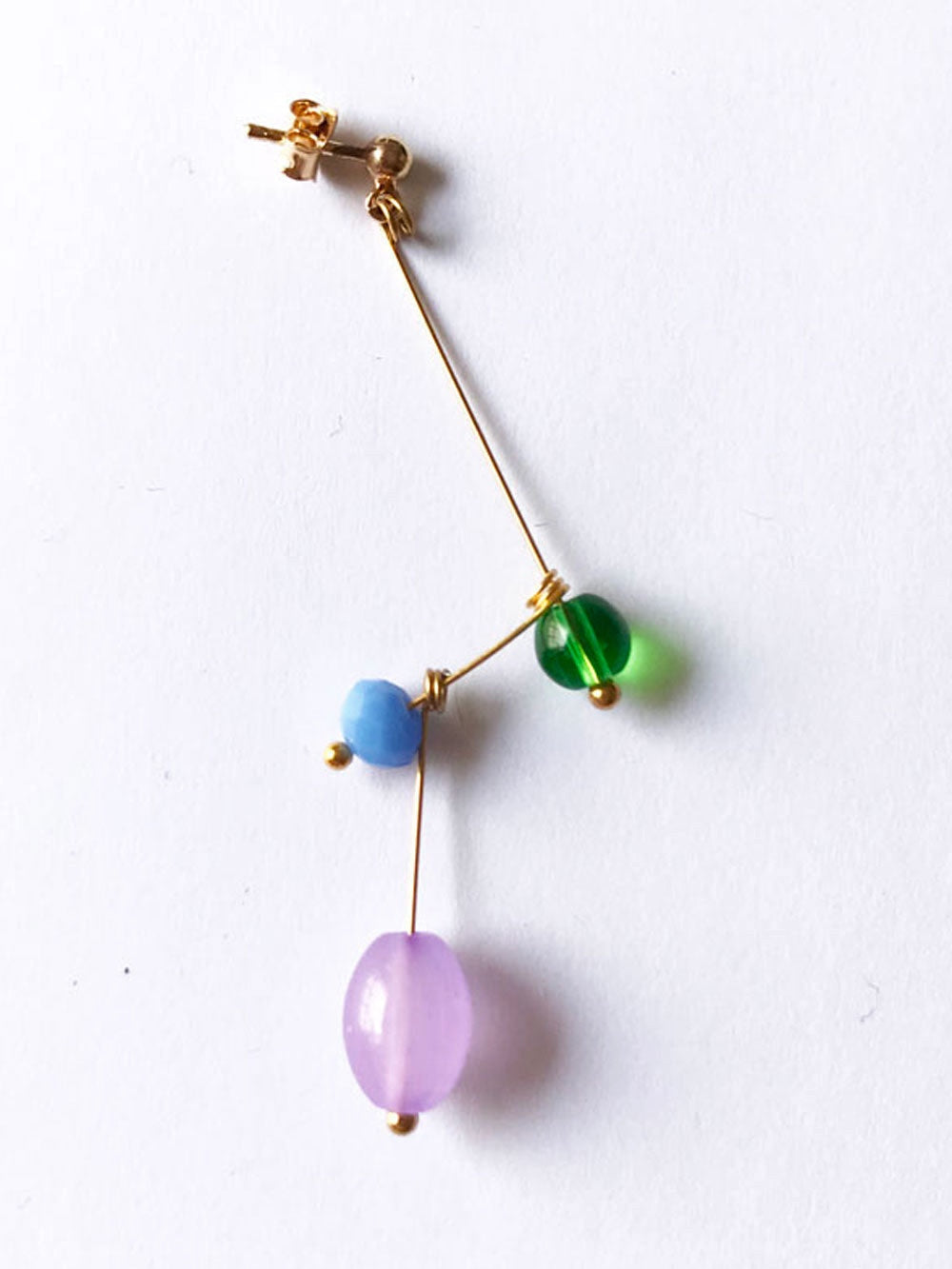 Petite boucle d'oreille mobile n°9, perles verte, bleu ciel et mauve, sur fond blanc