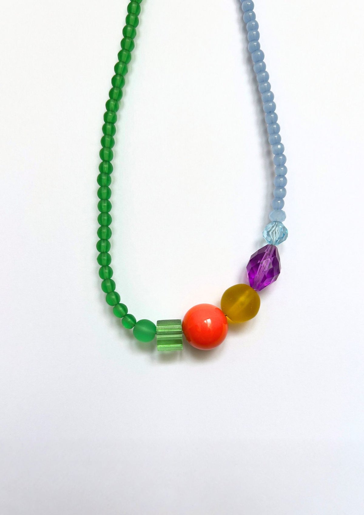 Collier de perles vert, bleu et multicolore : gros plan sur les perles orange, ambre, violette et verte au centre