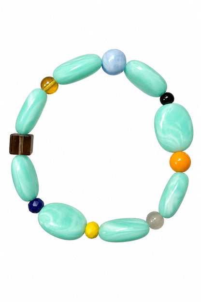 Bracelet élastique en perles vintage n°24, perles vert d'eau et petites perles colorées, tenu en main