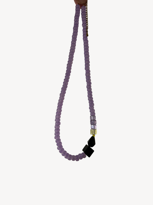 Collier ras du cou en perles de verre mauve, perles noires et fermoir acier, sur fond clair