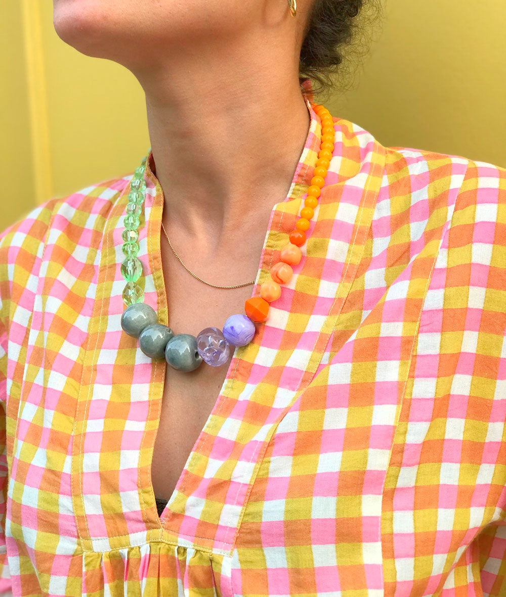 Collier en grosses perles orange, vertes et grises porté, vue de profil