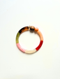 Petit bracelet pièce unique n°10 en perles tubes écaille, kaki, rose, crème, rouge et pêche, perle en bois, perle ronde pêche et perle ambrée, posé sur fond blanc