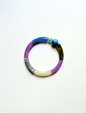 Petit bracelet pièce unique n°14 en perles tubes bleu, lavande, gris, crème et kaki, perle bleue marbrée et perle verte facettée, posé sur fond blanc