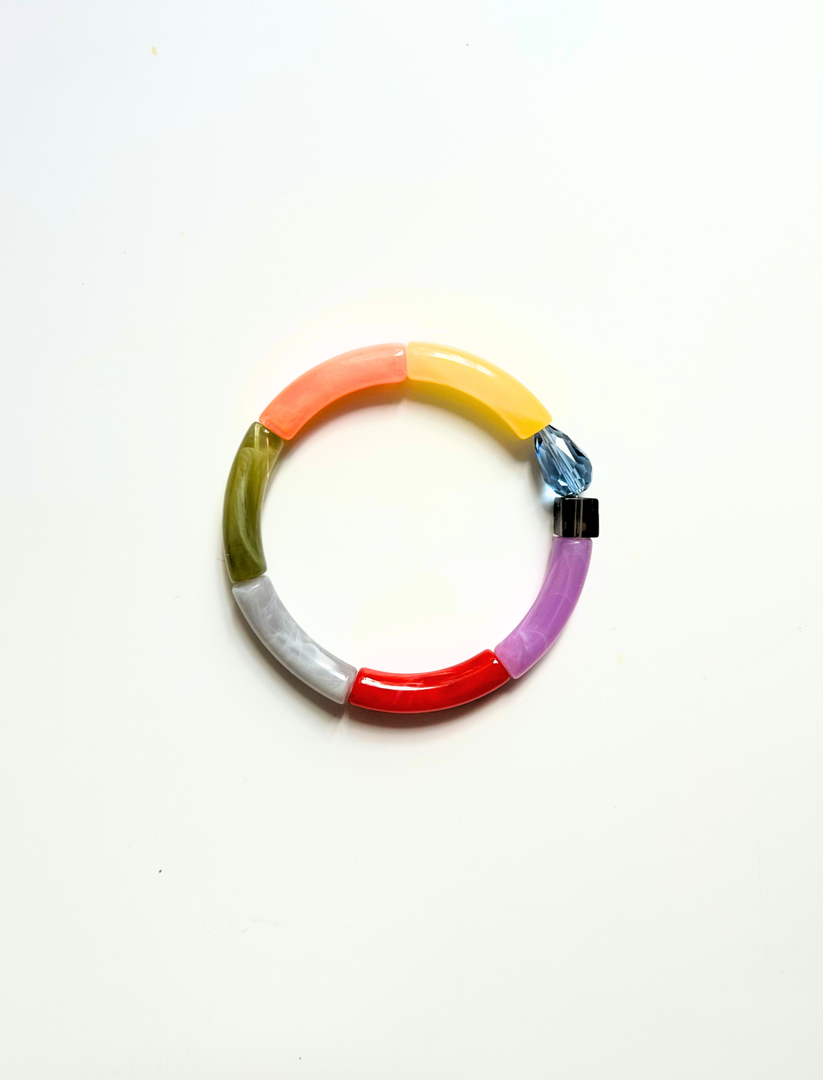 Petit bracelet pièce unique n°16 en perles tubes corail, jaune, kaki, gris, rouge et lavande, goutte bleue facettée et cube fumé, posé sur fond blanc