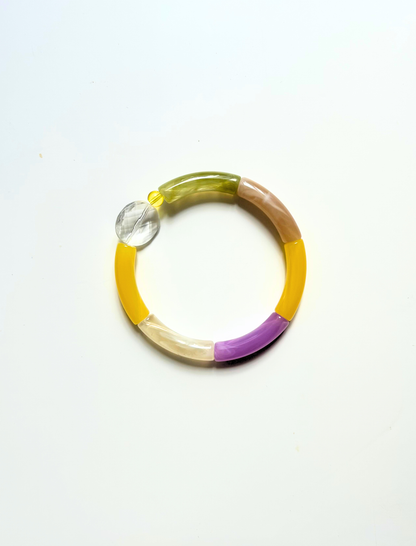 Petit bracelet pièce unique n°4 en perles tubes kaki, taupe, jaune, lavande et crème, perle transparente facettée et perle jaune, posé sur fond blanc