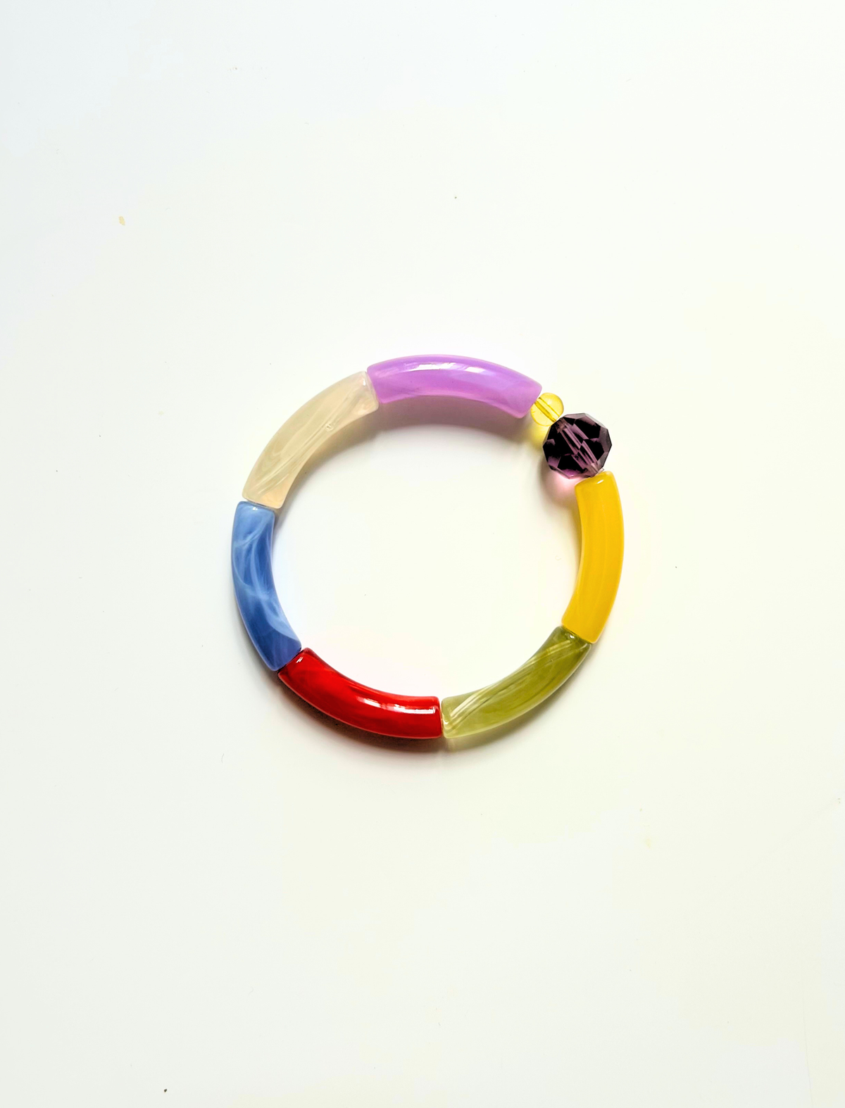 Petit bracelet pièce unique n°5 en perles tubes lavande, crème, bleu, rouge, kaki et jaune, perle violette facettée et perle jaune, posé sur fond blanc