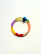 Petit bracelet pièce unique n°8 en perles tubes vert anis, lavande, jaune, rouge, taupe et corail, perle bleue et noire facettée, perle verte ovale, posé sur fond blanc