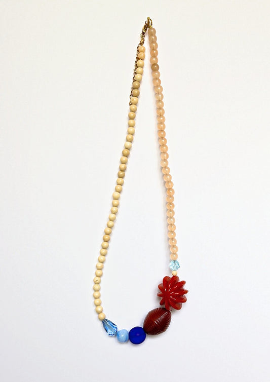 Collier asymétrique Maison Chouquette en perles beige et pêche, fleur rouge brique, perle marron rayée et dégradé de bleus – vue d'ensemble