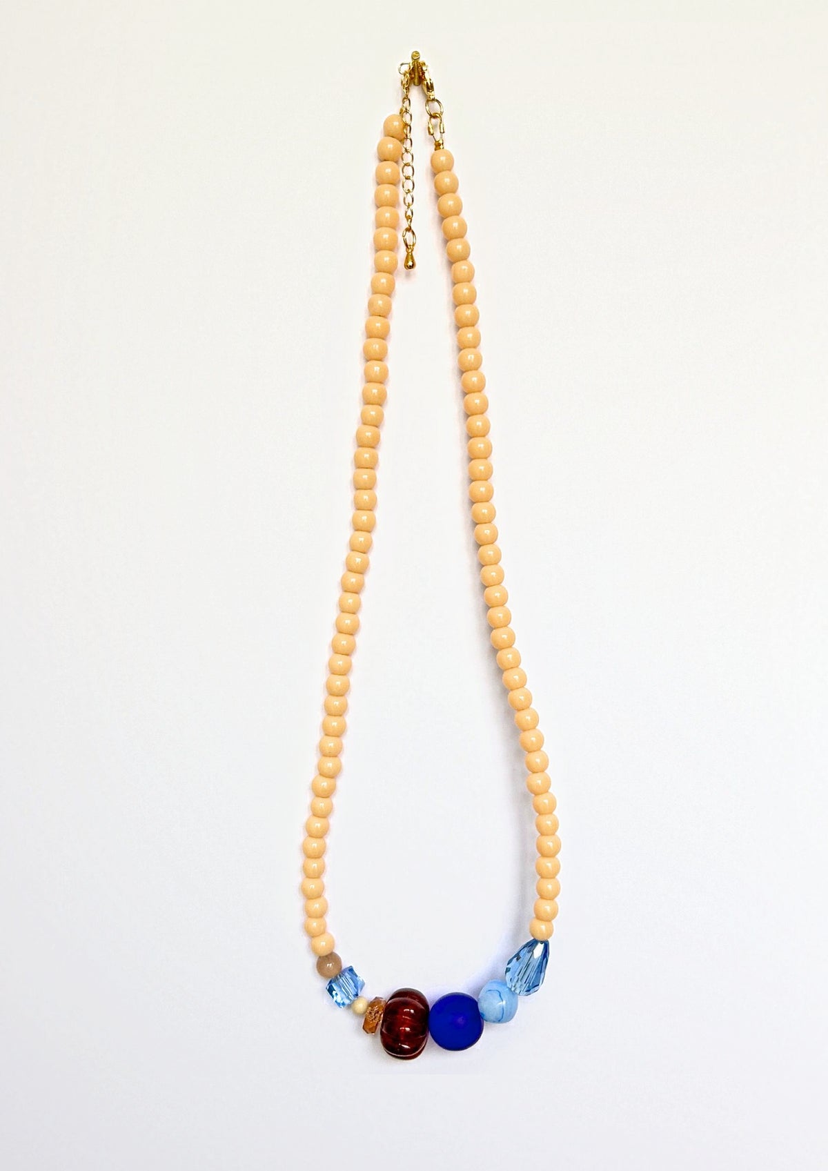 Collier de perles beige Maison Chouquette avec au centre une perle côtelée marron, une perle bleu roi et des facettes bleu glacier – vue d'ensemble