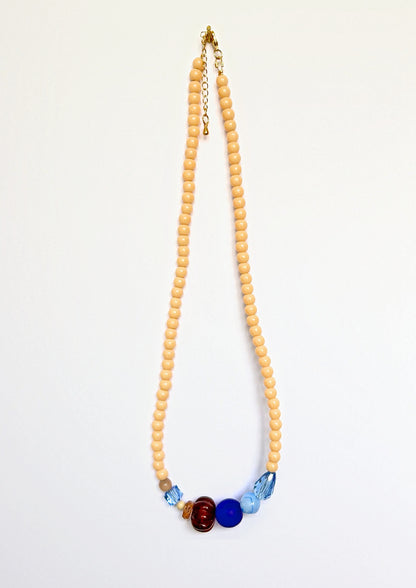 Collier de perles beige Maison Chouquette avec au centre une perle côtelée marron, une perle bleu roi et des facettes bleu glacier – vue d'ensemble
