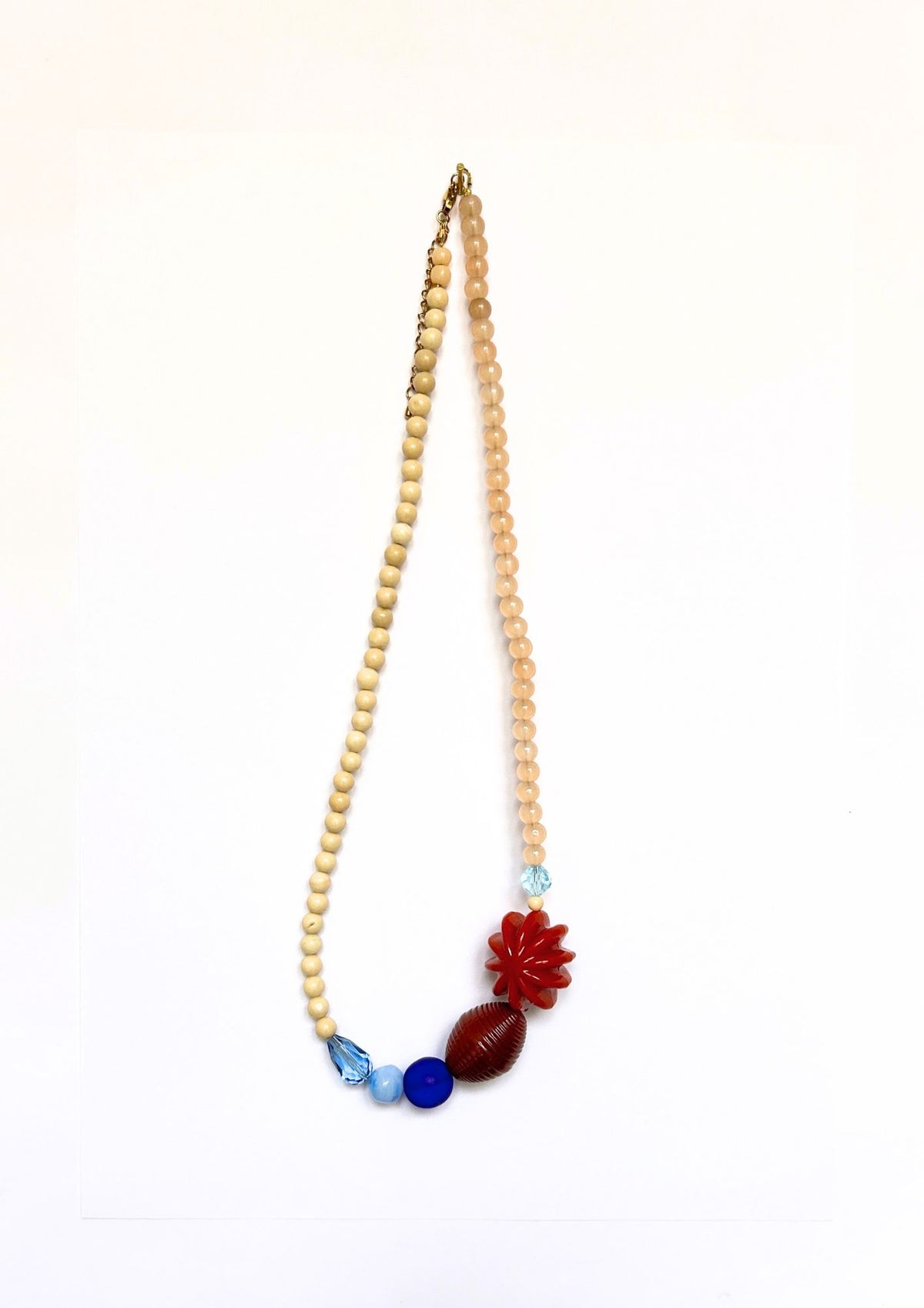 Collier de perles beige, bleu et fleur rouge, vue d’ensemble