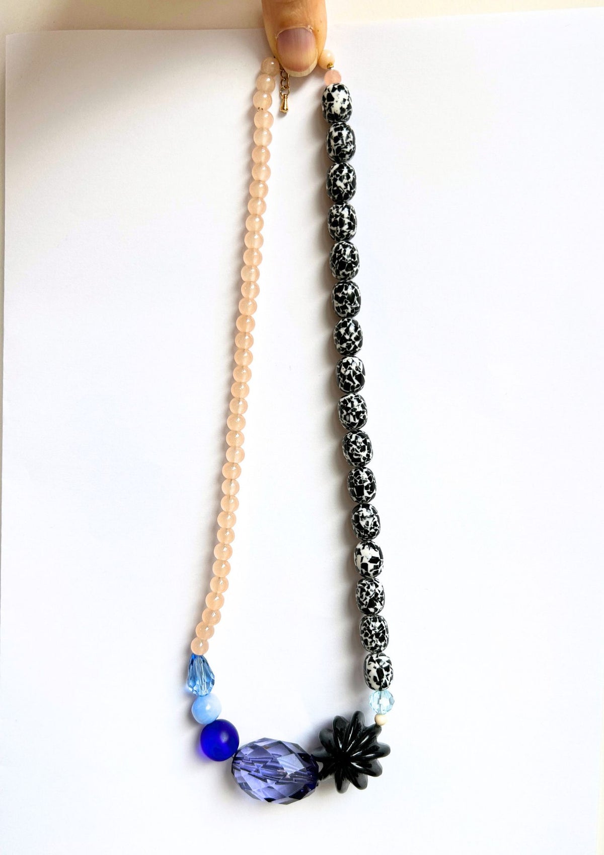 Collier de perles rose, noir et bleu, vue d’ensemble, un côté rose poudré et un côté noir et blanc