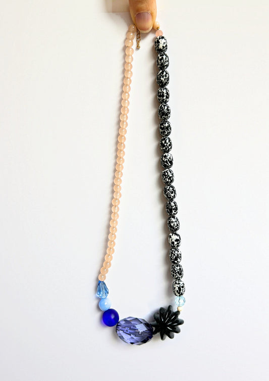 Collier de perles rose, noir et bleu, vue d’ensemble, un côté rose poudré et un côté noir et blanc